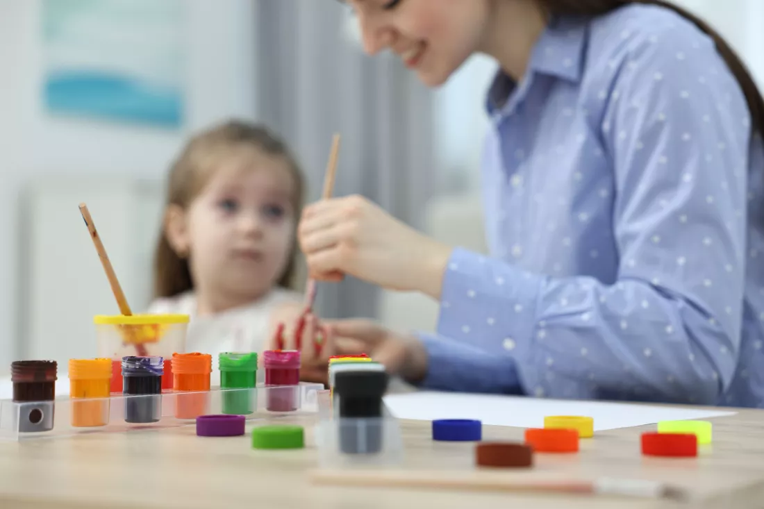 mother-her-little-daughter-painting-with-palms-home-selective-focus